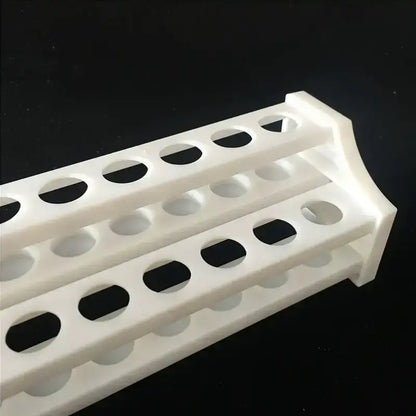 Close-up van openingen Ø14 mm in wit kunststof rek